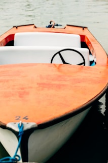 white and orange boat on water