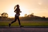woman in black sports bra and black pants running on water during sunset
