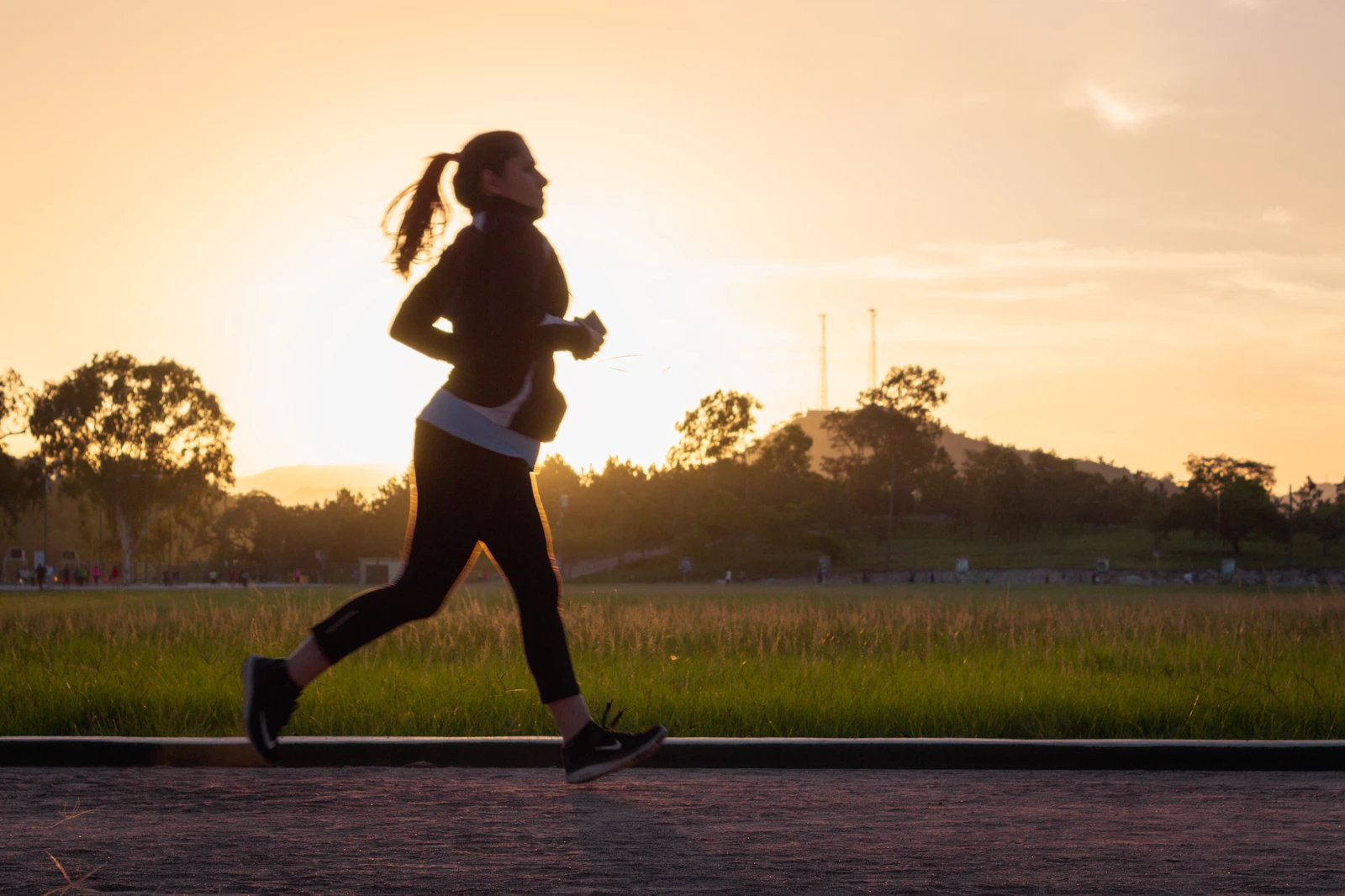 Femme qui marche en fin de journée au coucher du soleil, silhouette en mouvement