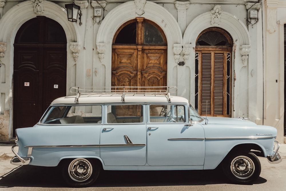 white station wagon parked beside brown building