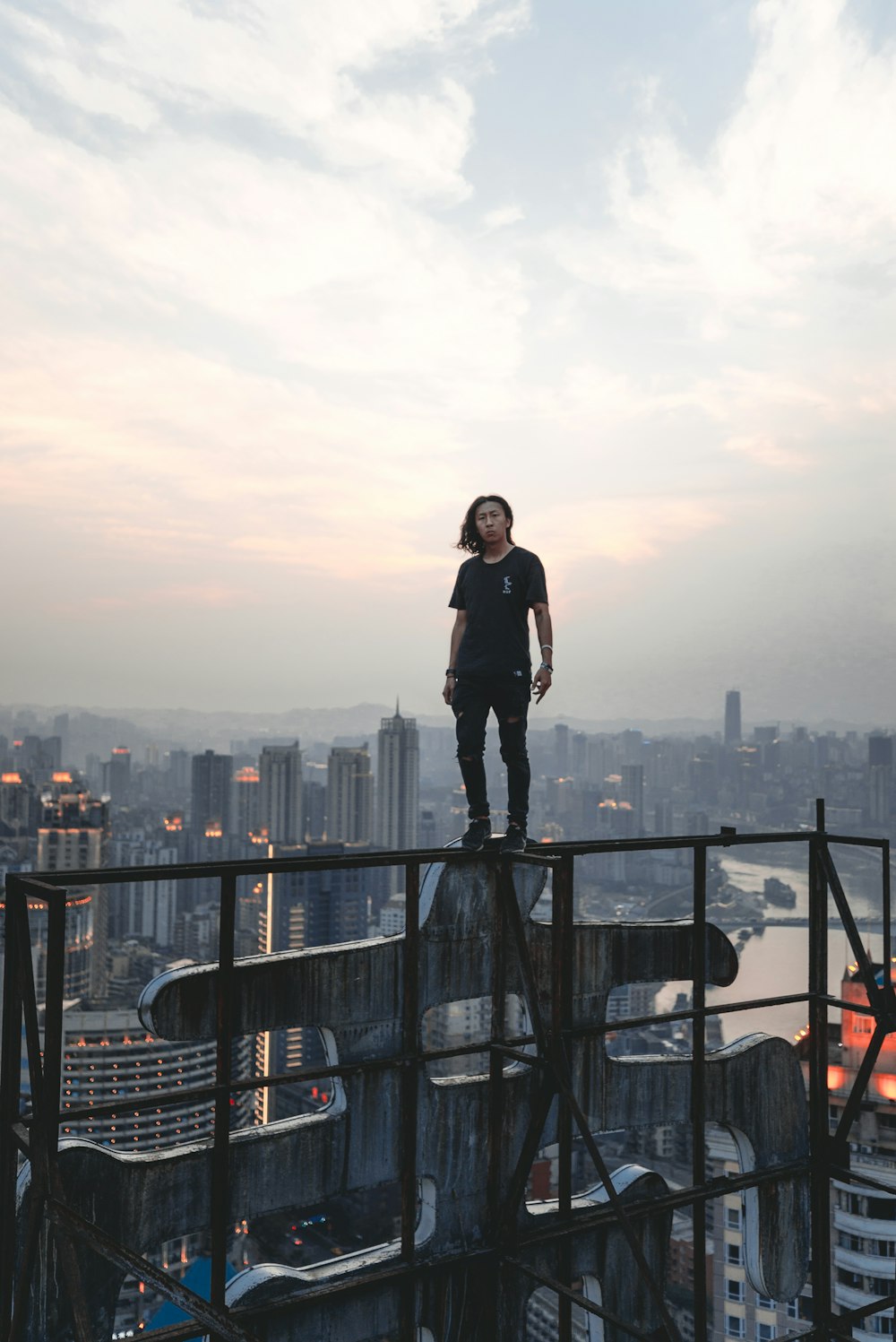 woman in black jacket standing on black metal railings during daytime