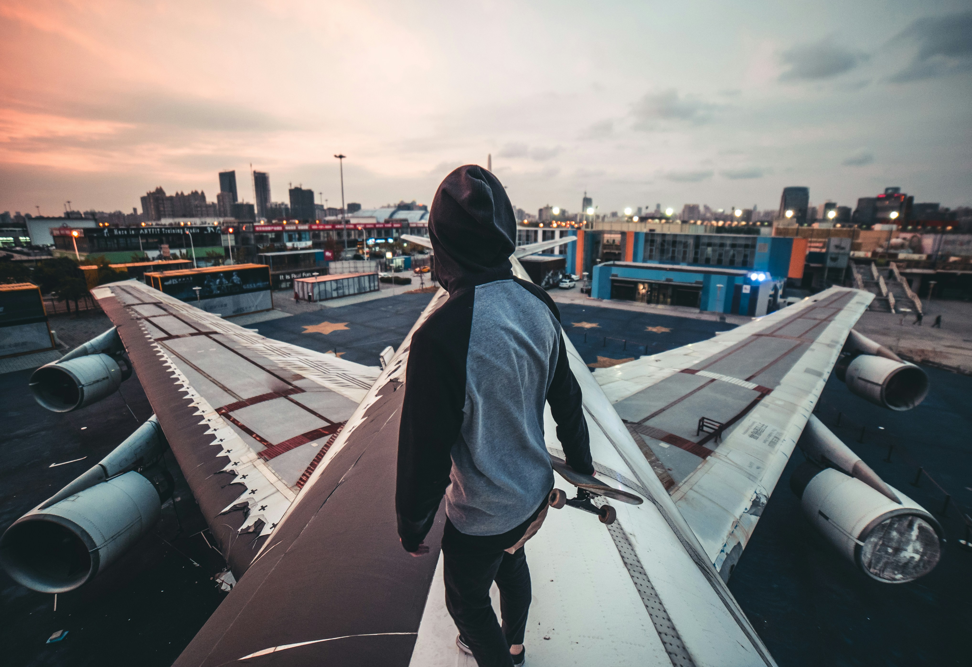 man in blue denim jacket standing on top of building during daytime, 