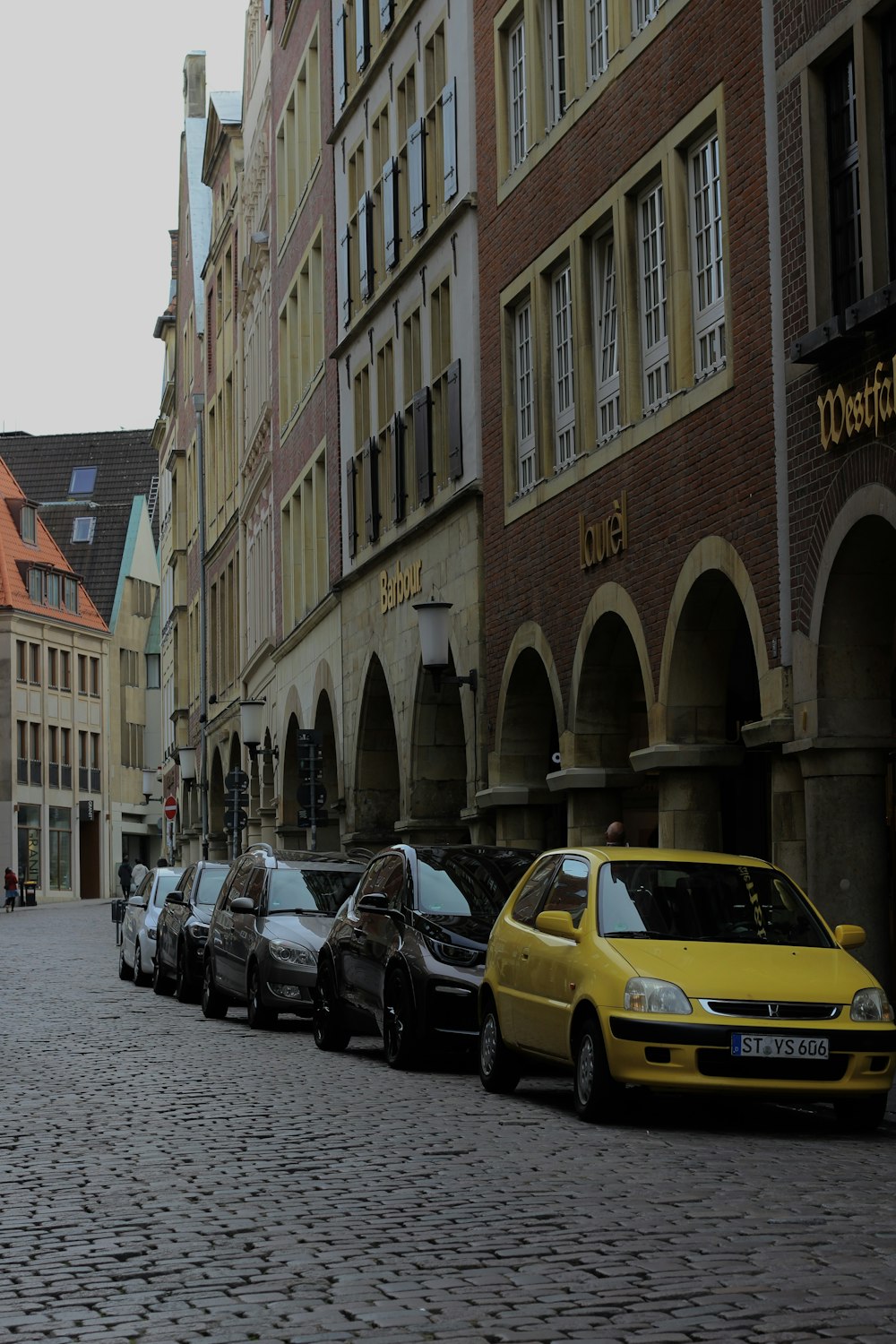 cars parked beside brown concrete building during daytime