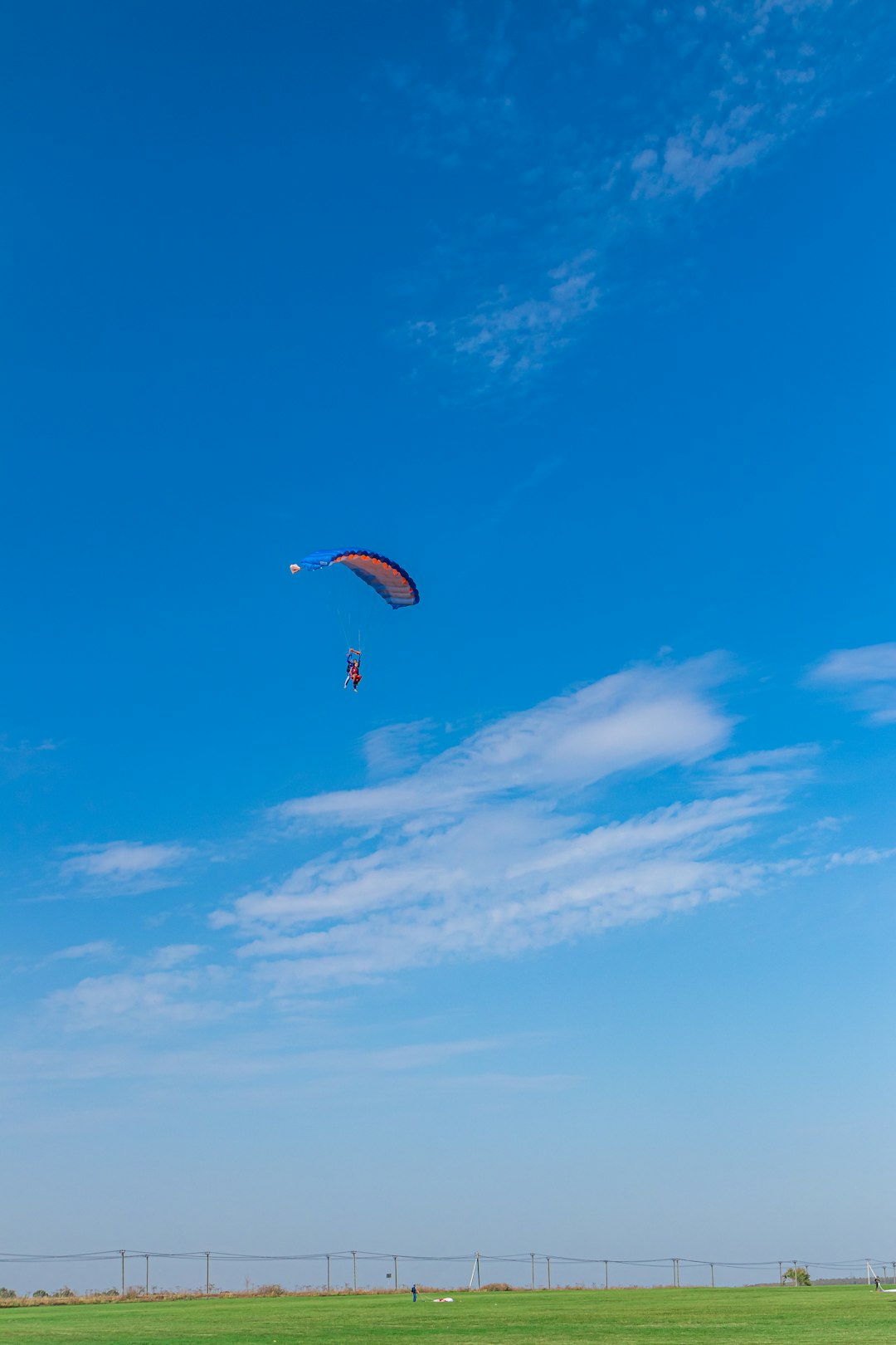 person in parachute under blue sky during daytime