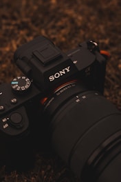 black nikon dslr camera on brown and black textile