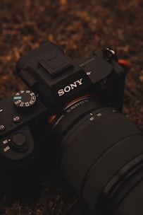 black nikon dslr camera on brown and black textile