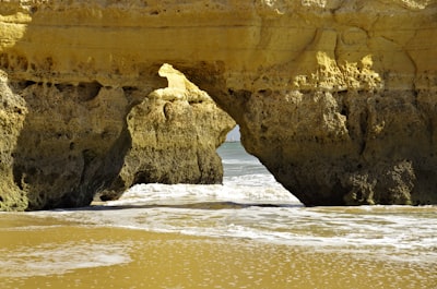 brown rock formation on sea shore during daytime coast teams background