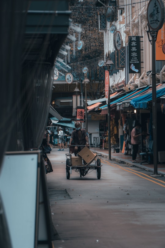 people sitting on chair near store during daytime in Chinatown Singapore