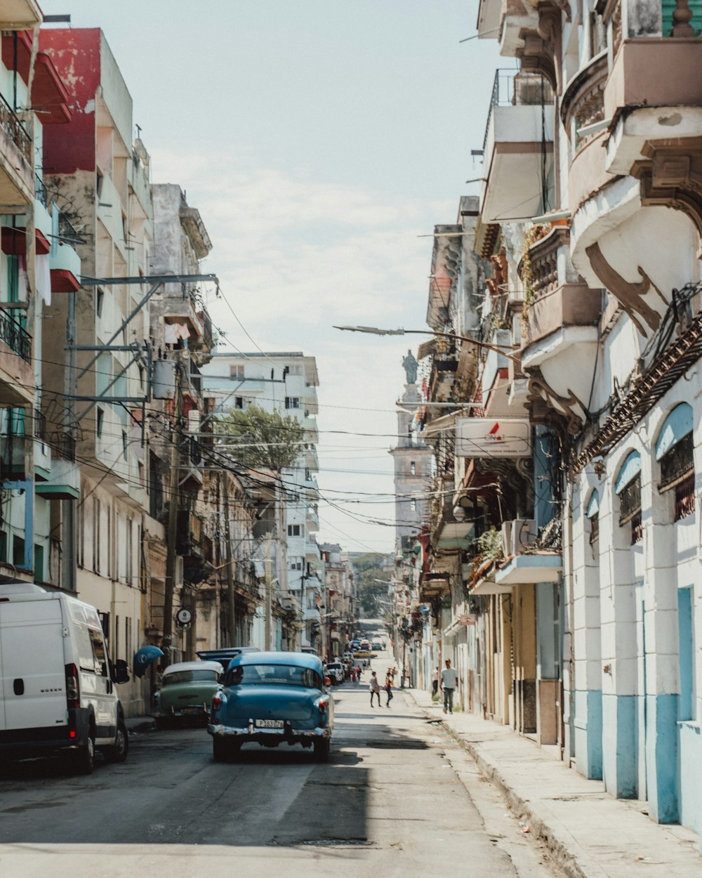 cars parked on street between buildings during daytime