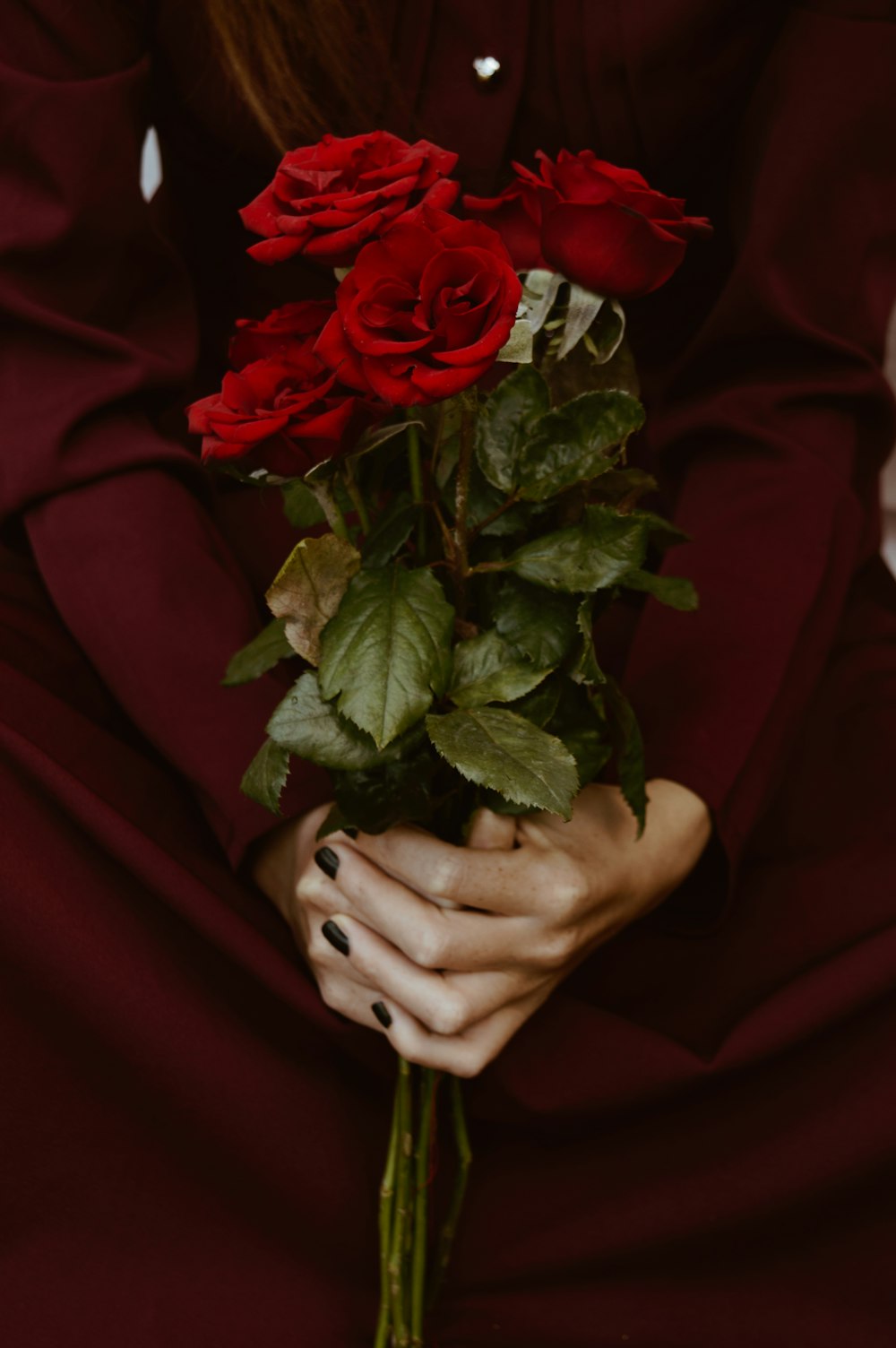 person holding red rose bouquet