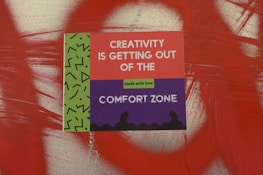 a sign on a wall that says creativity is getting out of the comfort zone