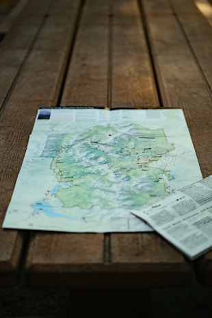 Close-up of a detailed topographic map spread out on a wooden table.