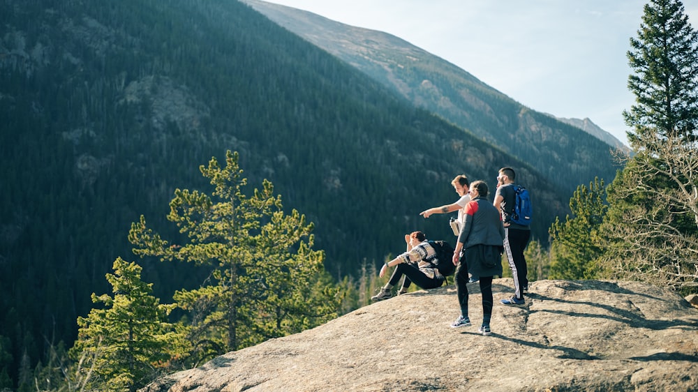 people standing on rocky hill during daytime