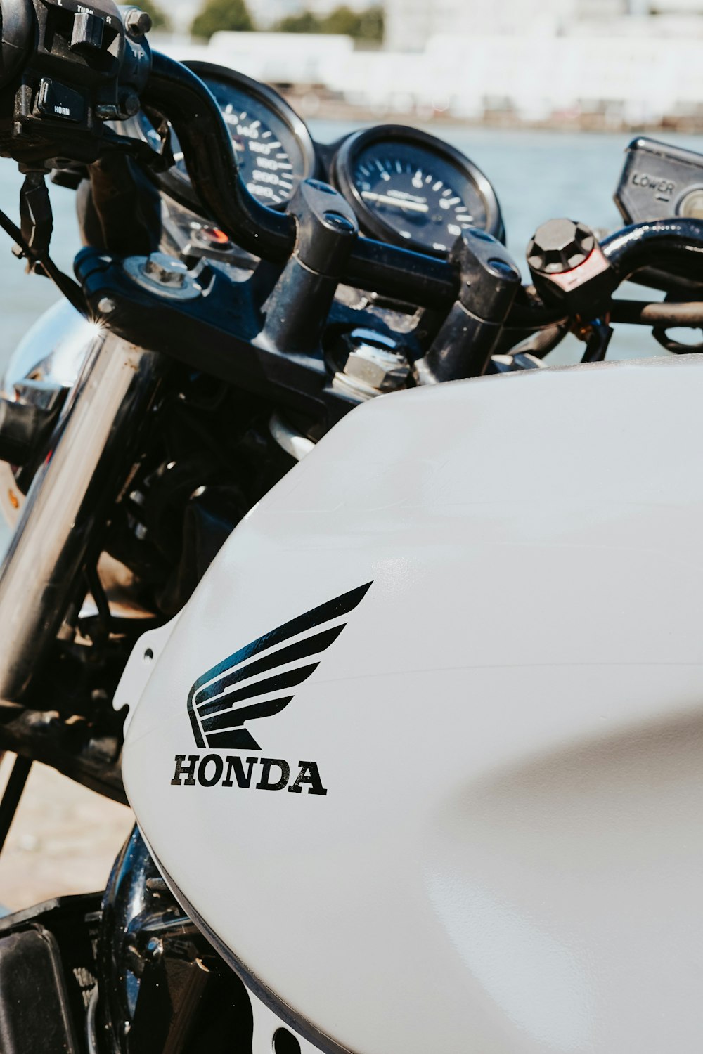 a close up of a motorcycle parked near a body of water