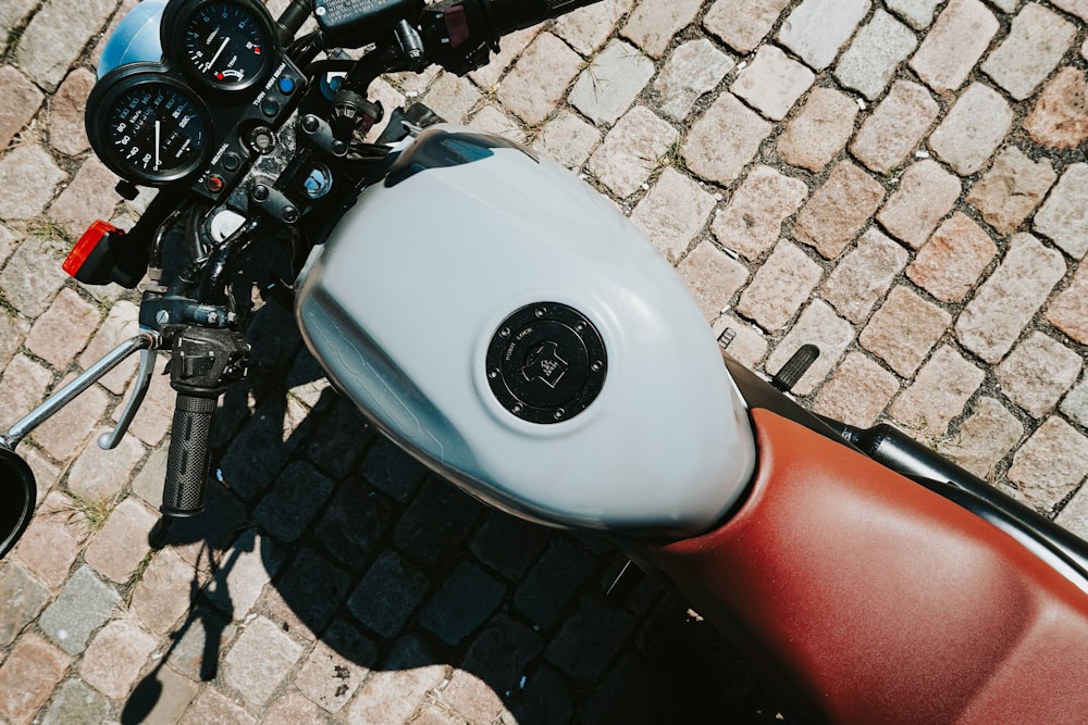 a close up of a motorcycle parked on a brick road