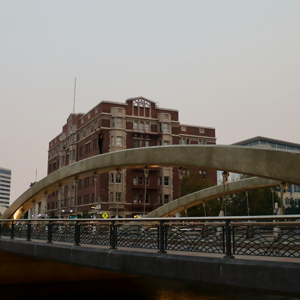 Puente de hormigón gris cerca de un edificio de gran altura durante el día