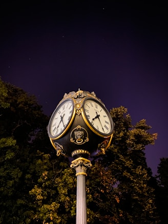 A vintage ornate clock glowing softly under a starry night sky