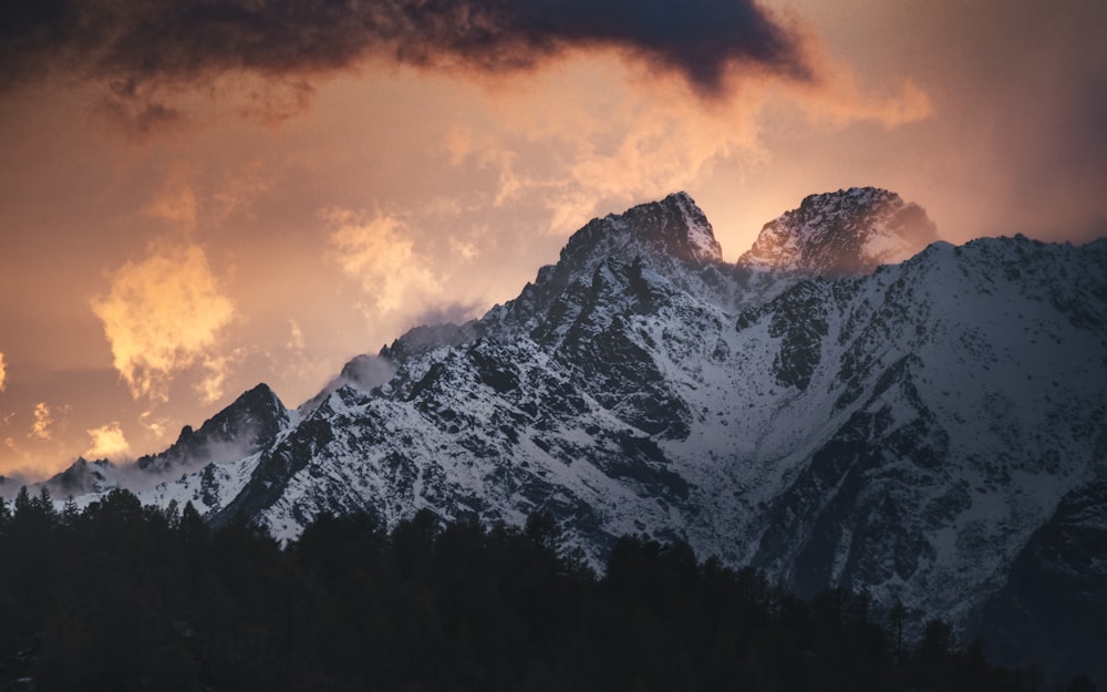 black and white mountain under orange sky