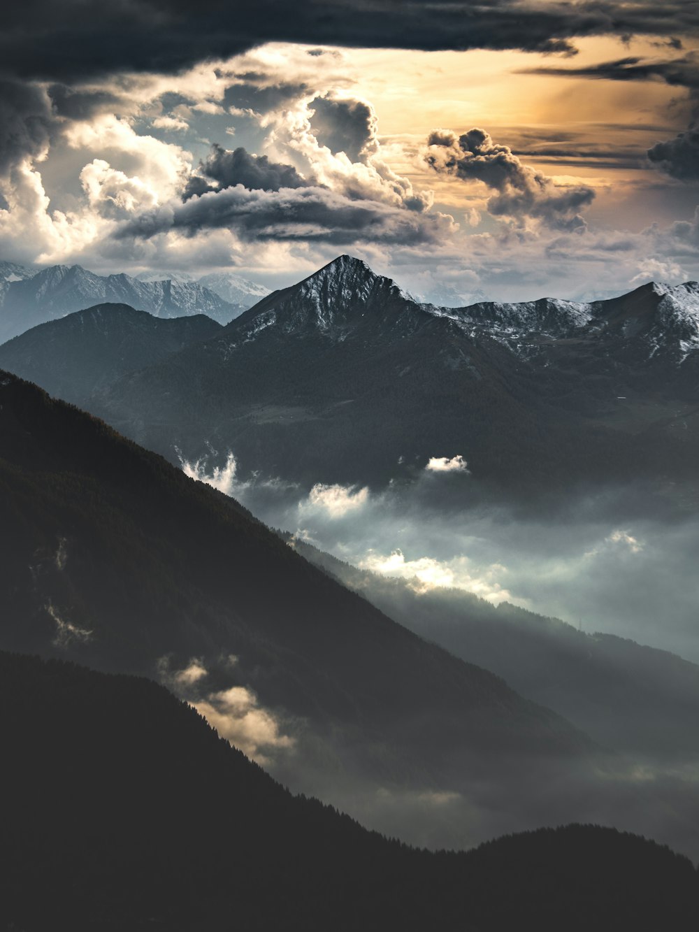 montagnes noires et blanches sous un ciel nuageux pendant la journée