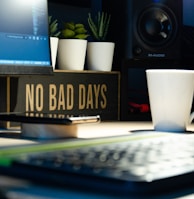 white ceramic mug beside black computer keyboard