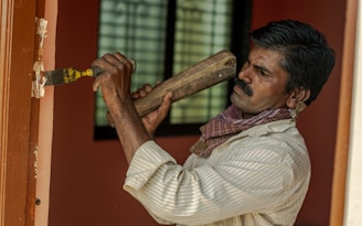 man in white and brown pinstripe dress shirt holding brown wooden stick
