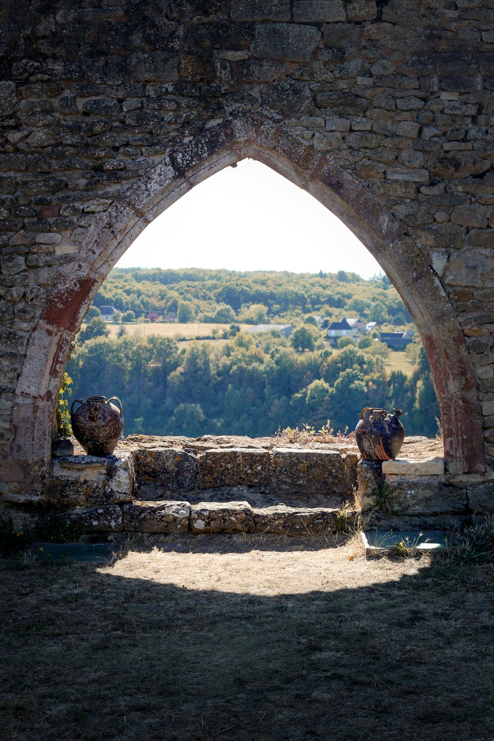 brown brick arch near green grass field during daytime