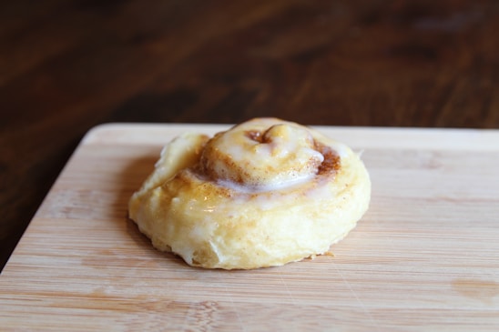 A freshly baked cinnamon roll with a drizzle of icing.