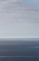 Crew members sharing a quiet moment on deck, the vast ocean stretching endlessly around them.