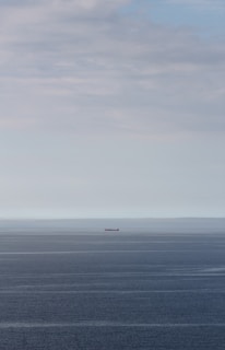 Crew members sharing a quiet moment on deck, the vast ocean stretching endlessly around them.