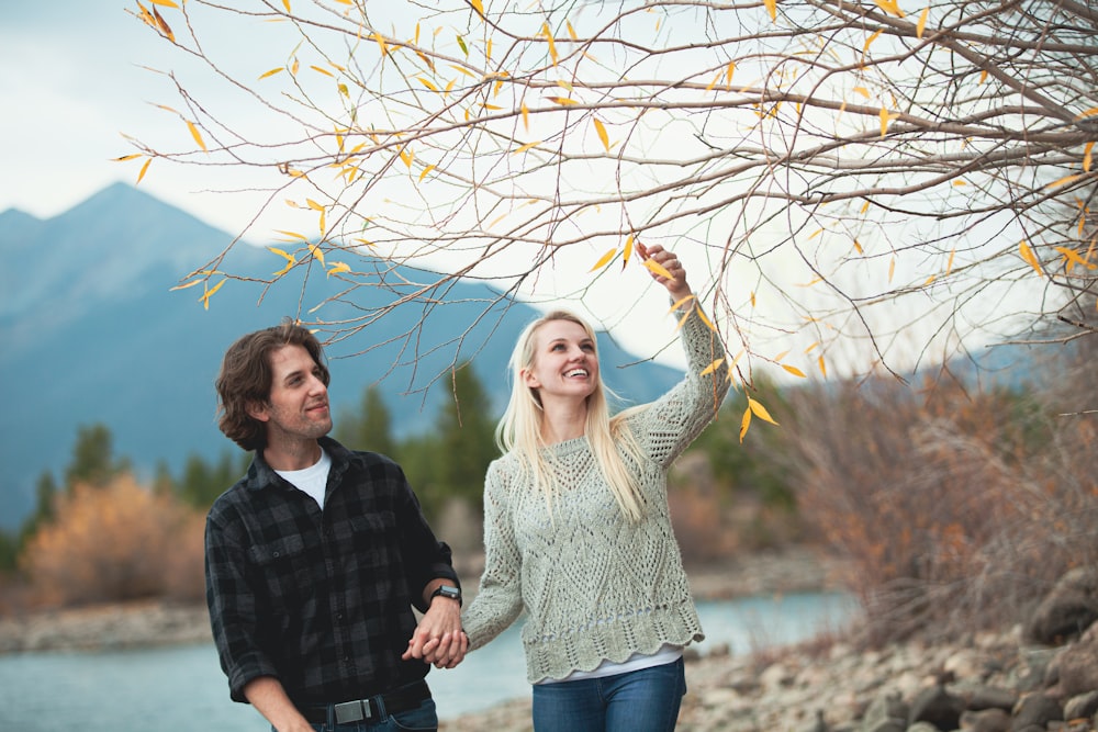 Mann und Frau, die tagsüber weiße und braune getrocknete Blätter halten