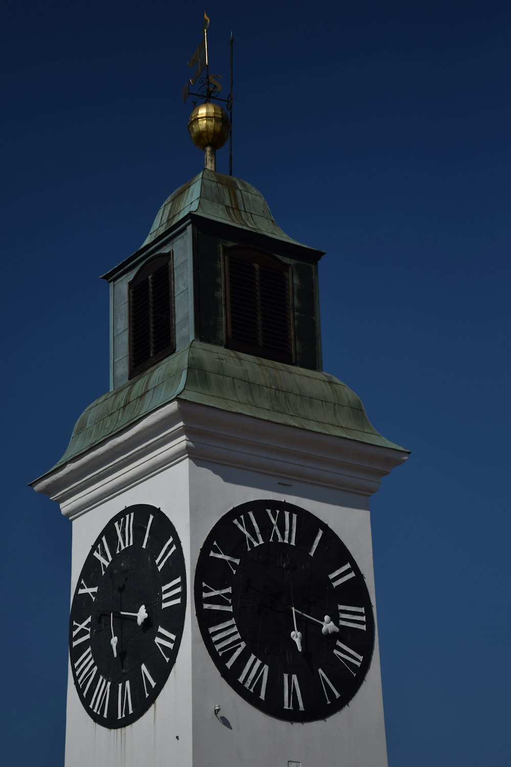 Torre de reloj blanca y negra bajo el cielo azul durante el día