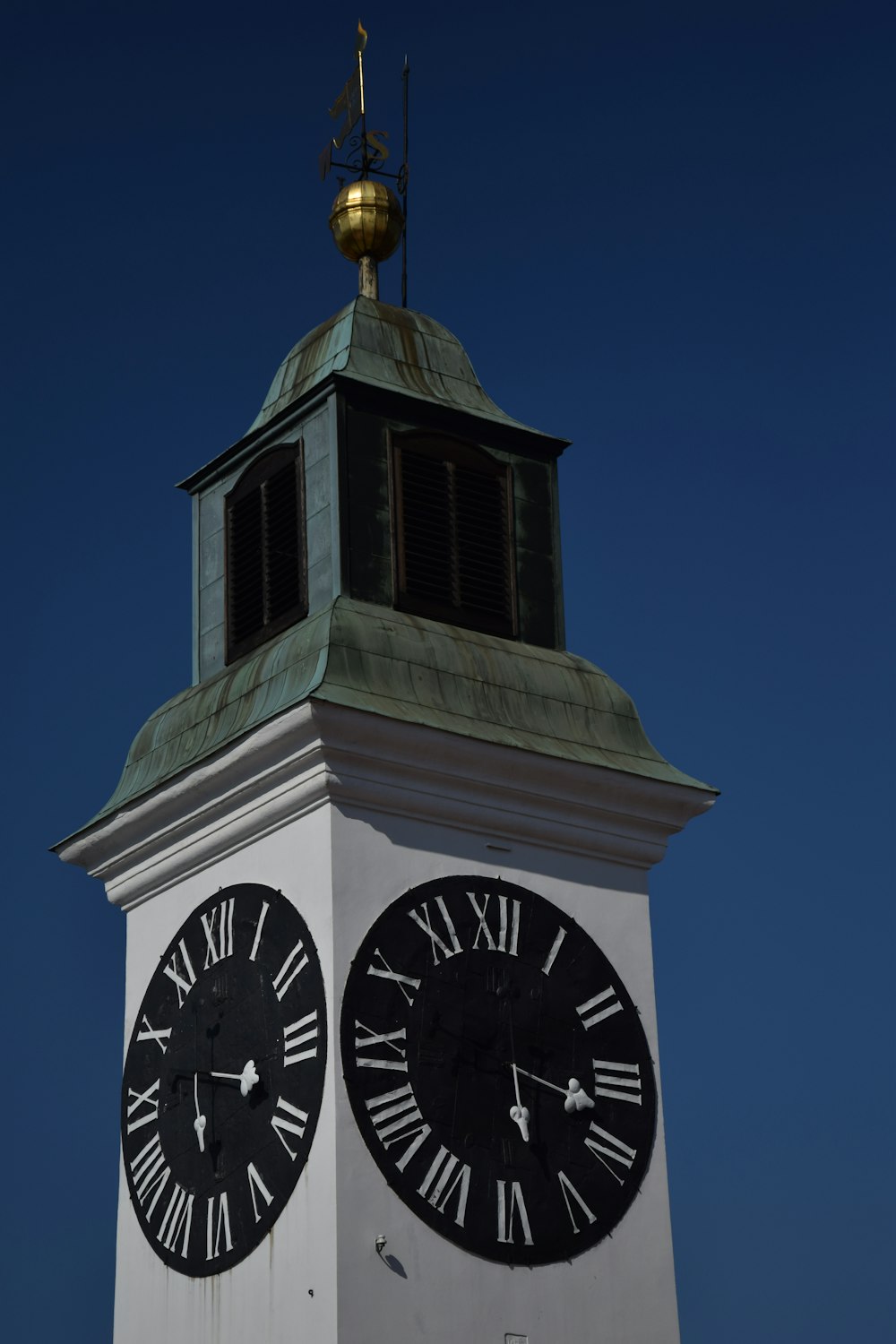 Torre dell'orologio bianca e nera sotto il cielo blu durante il giorno