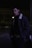 man in black jacket standing on sidewalk during night time