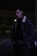 man in black jacket standing on sidewalk during night time