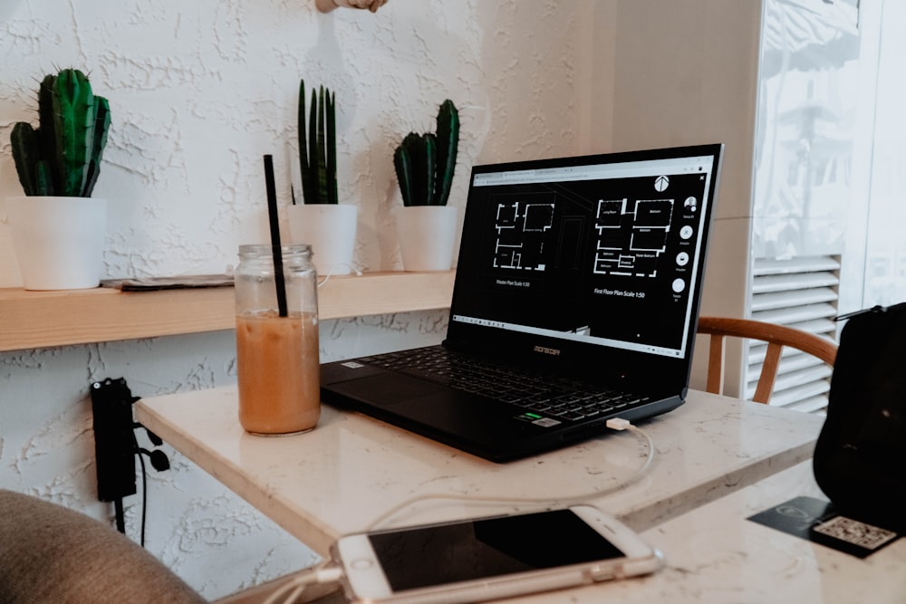 black laptop computer on brown wooden table