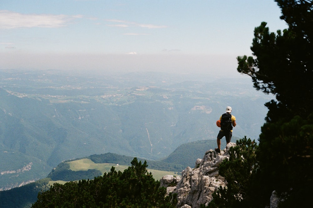 man in black shirt standing on rock formation during daytime