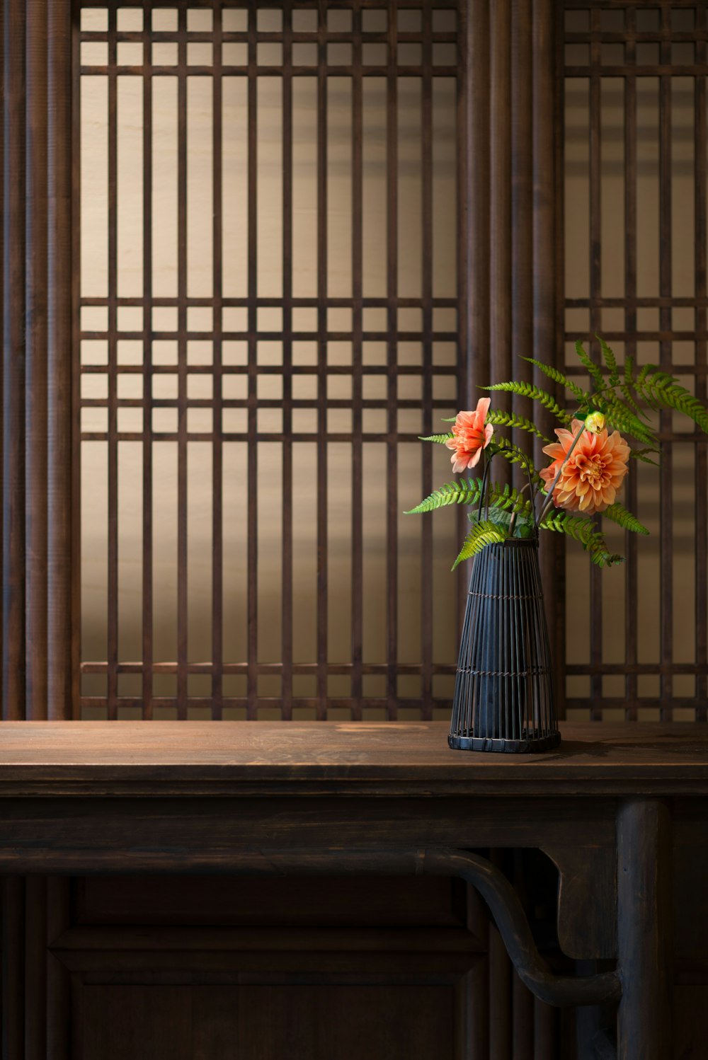 red and white flowers in blue vase on brown wooden table