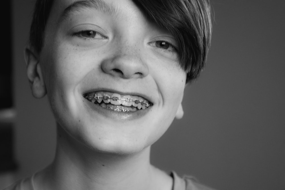 Photo en niveaux de gris d’une fille souriante