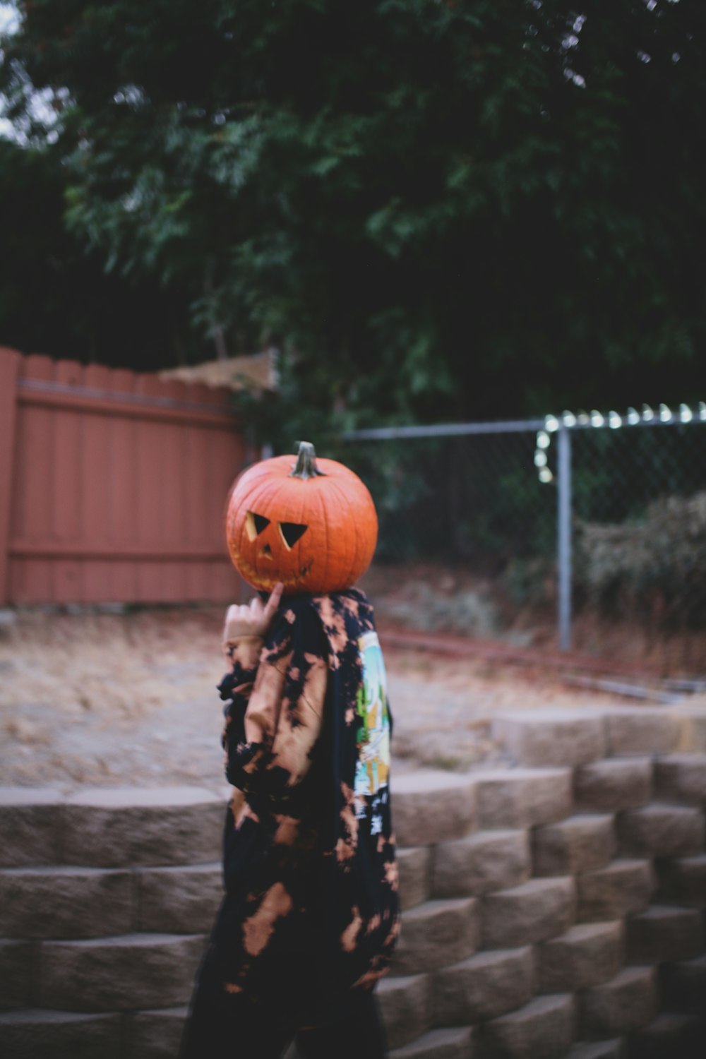woman in black and white floral dress holding jack o lantern