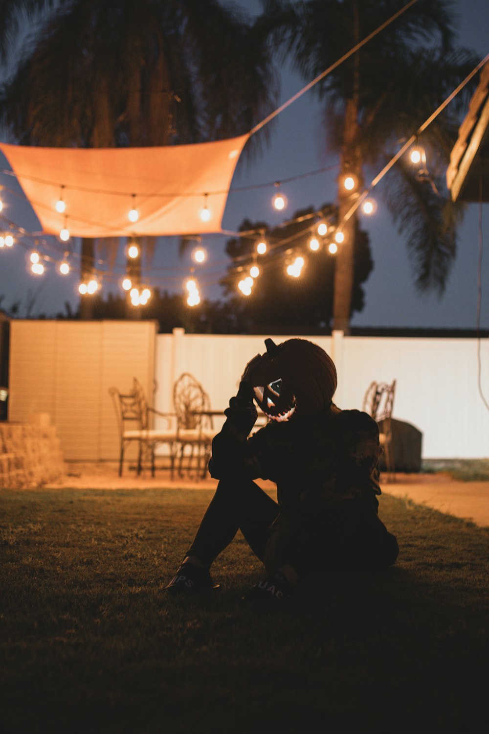 man in black jacket and pants sitting on ground during night time