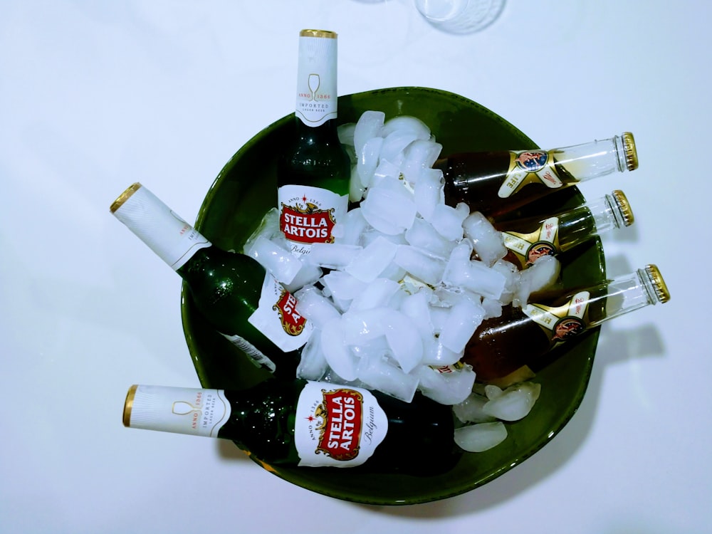 white and green labeled bottle on green glass bowl