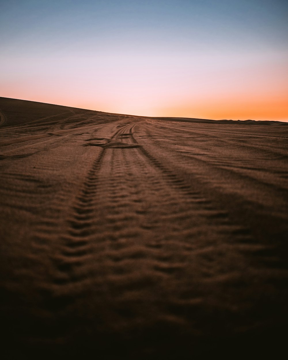 brown sand under orange sky during sunset