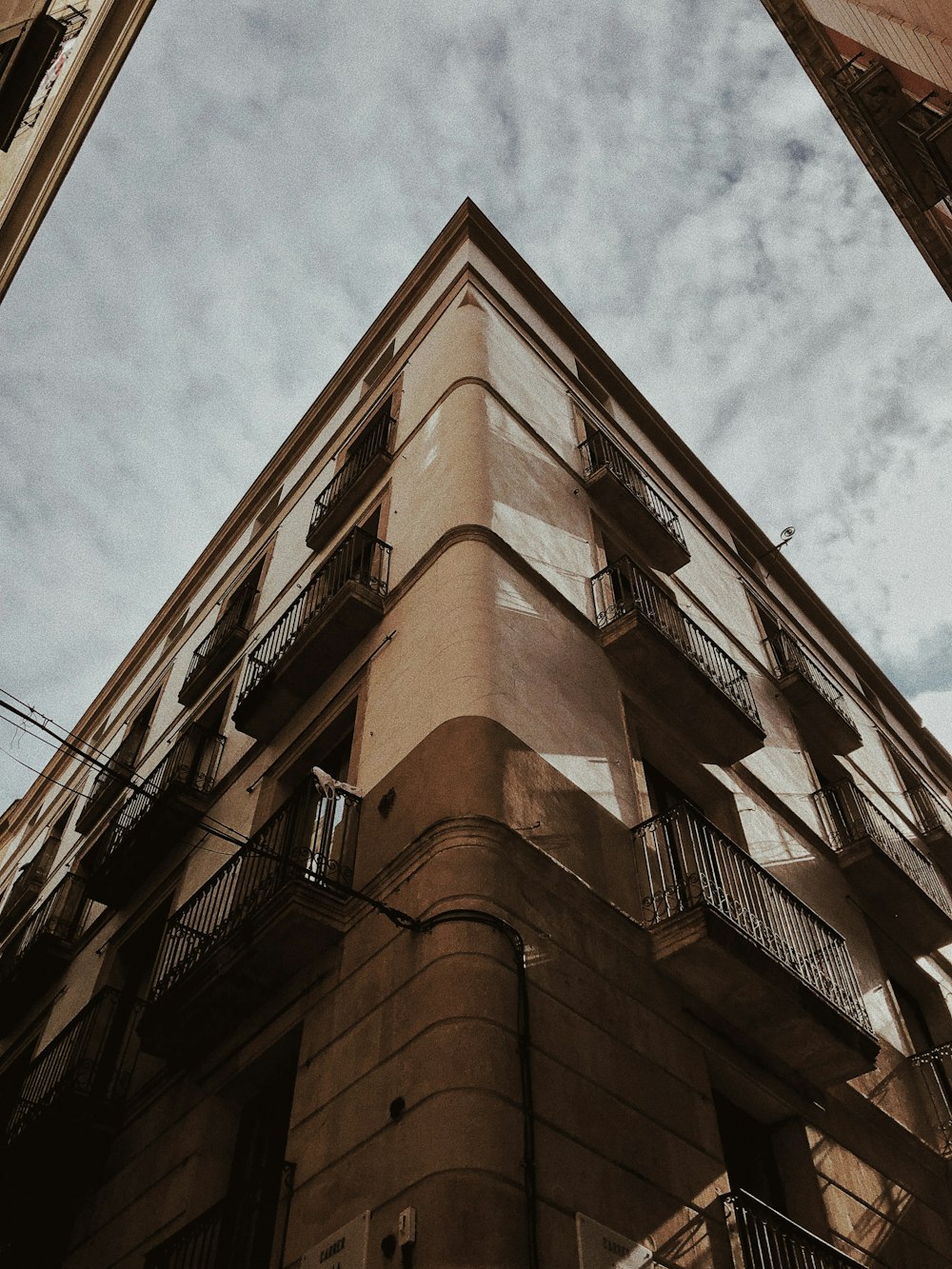 Edificio de hormigón marrón bajo nubes blancas durante el día