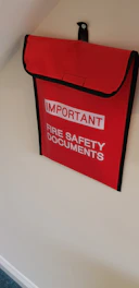 a red fire safety bag hanging on a wall