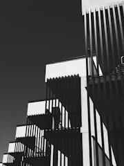 Black and white photo of a pristine commercial building exterior with sharp shadows emphasizing clean lines.