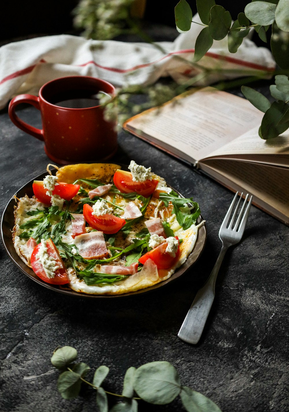 Salade de légumes sur assiette en céramique rouge à côté d’une fourchette en acier inoxydable