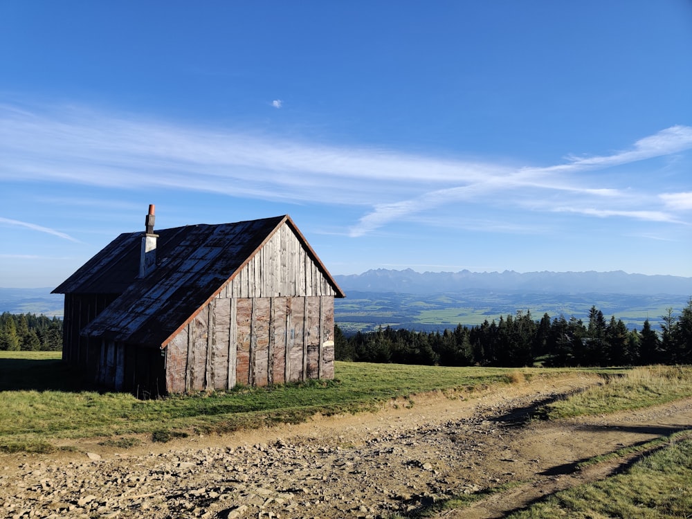 brown wooden house near green trees under blue sky during daytime