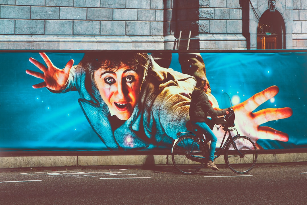 man riding bicycle with womans face graffiti