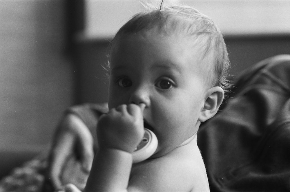 grayscale photo of baby with white bib