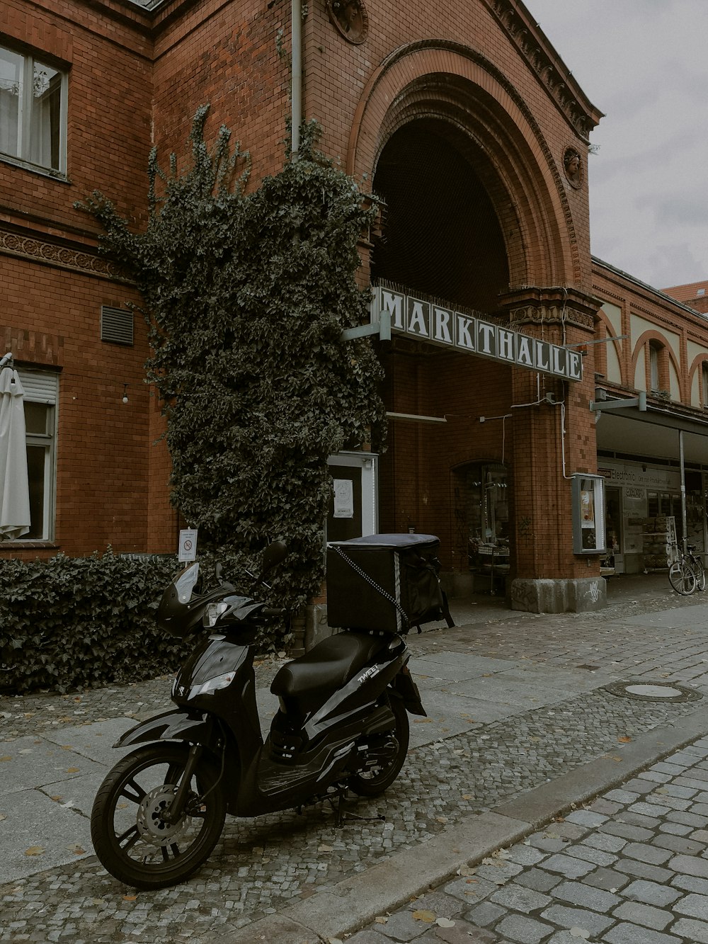 black motorcycle parked beside brown brick building